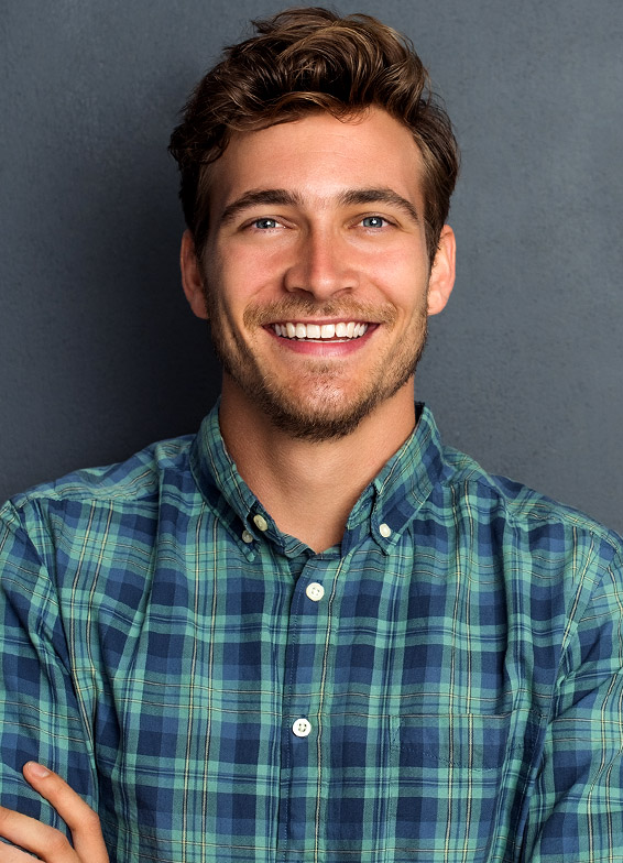 Male dental professional smiling in plaid shirt against gray background for dentistry practice.