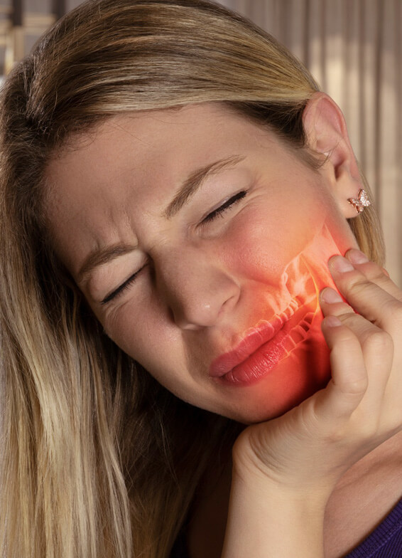 Woman holding jaw in pain with red inflammation highlighted on cheek and jaw area.