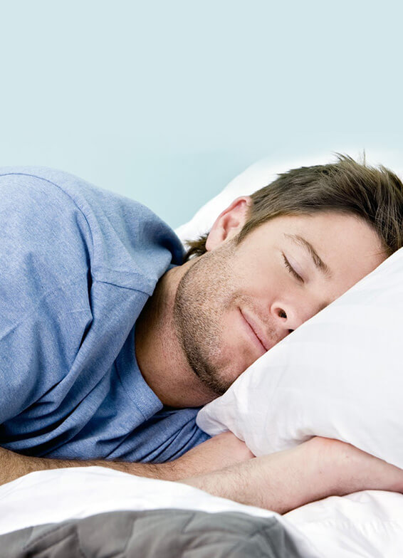 Man sleeping peacefully on white pillow, promoting quality sleep and dental health.