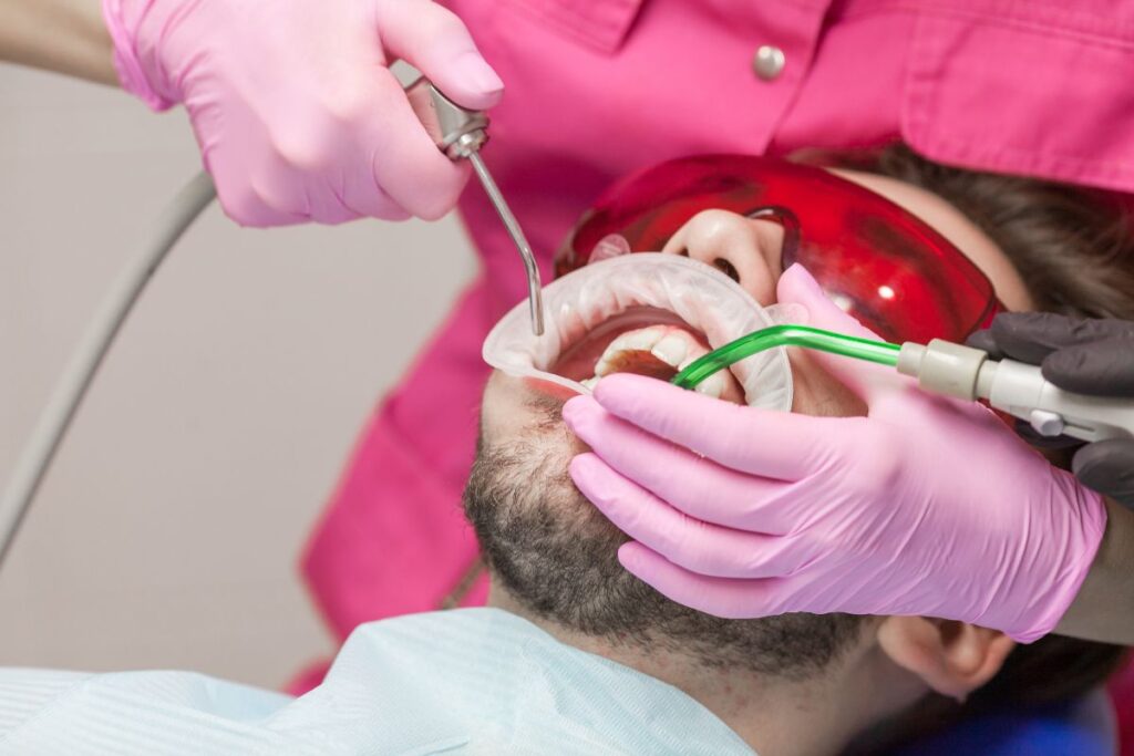 Dentist performing a professional dental cleaning on a patient in a dental office